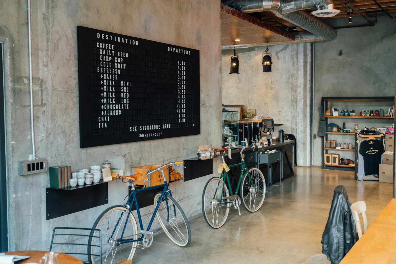 The roastery shop floor with a coffee menu board on the wall and two bicycles